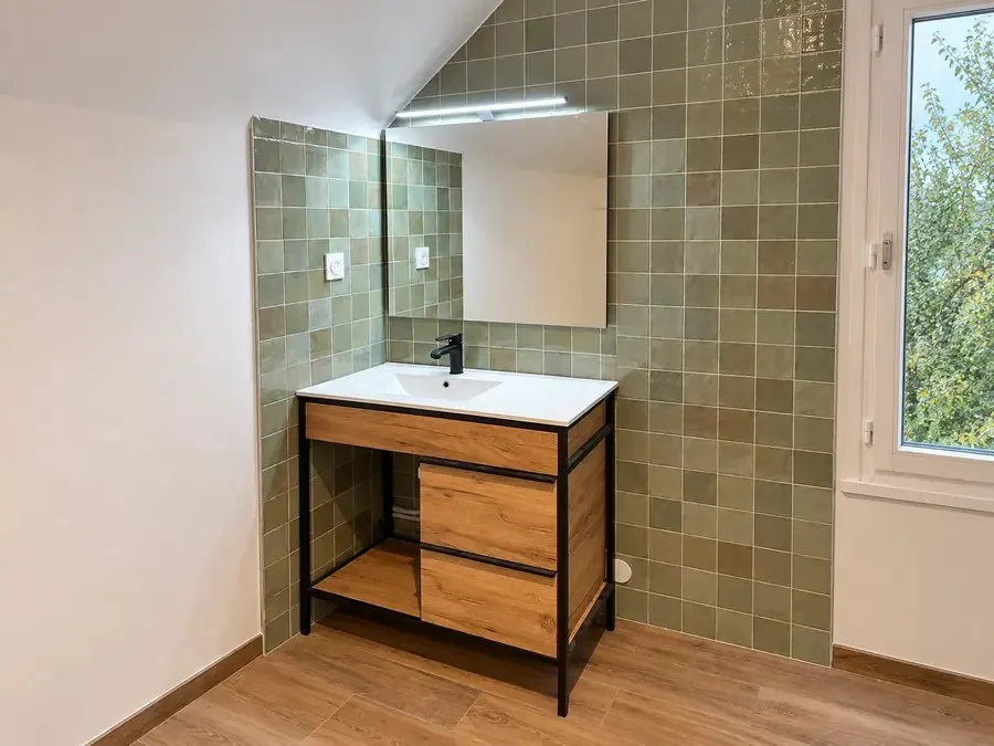 Salle de bains rénovée avec faïence verte et meuble vasque