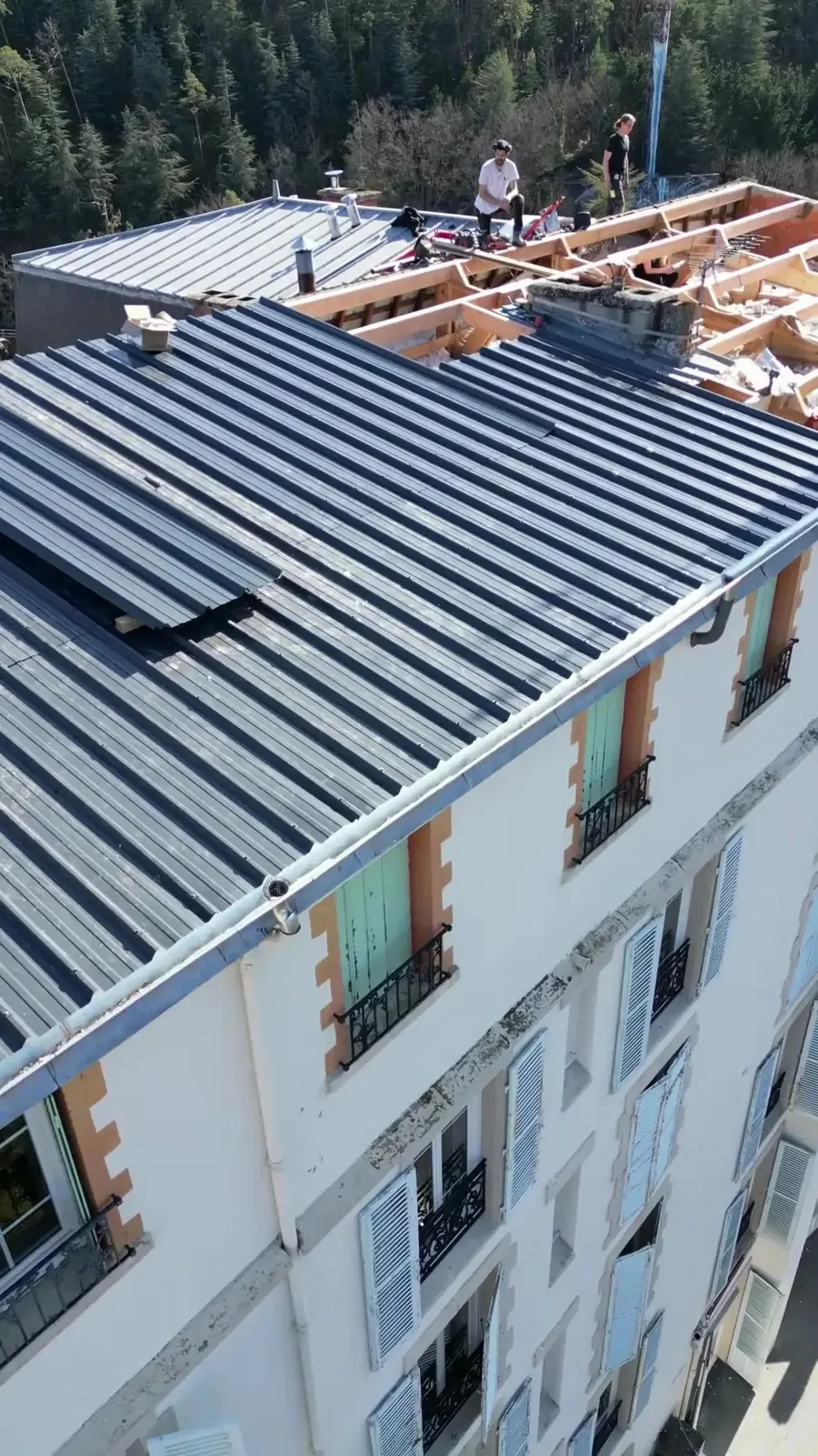 Compagnons sur la charpente d’un toit d’immeuble pendant la rénovation