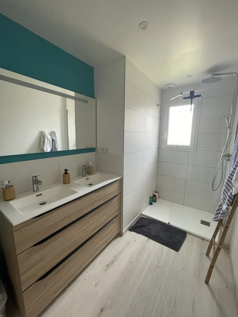 Salle de bains avec meuble double vasque en bois et douche